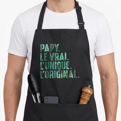 Tablier de cuisine noir avec inscription verte Papy le vrai l'unique l'original en lettres capitales stylisées.