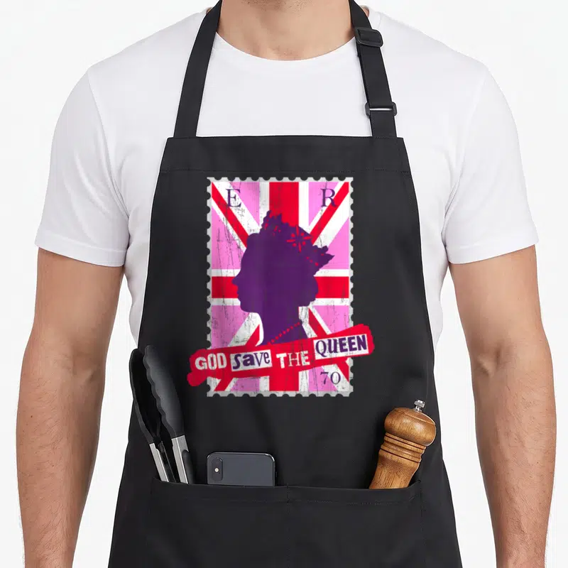 Tablier de cuisine noir avec motif timbre postal rose, silhouette reine et texte God Save the Queen 70.