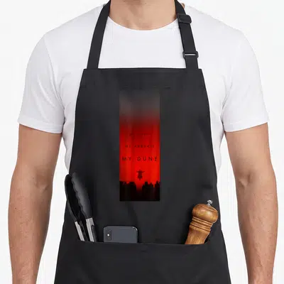Tablier de cuisine noir avec fond rouge dégradé, texte noir et silhouette centrale au-dessus d'un groupe en bas de page.