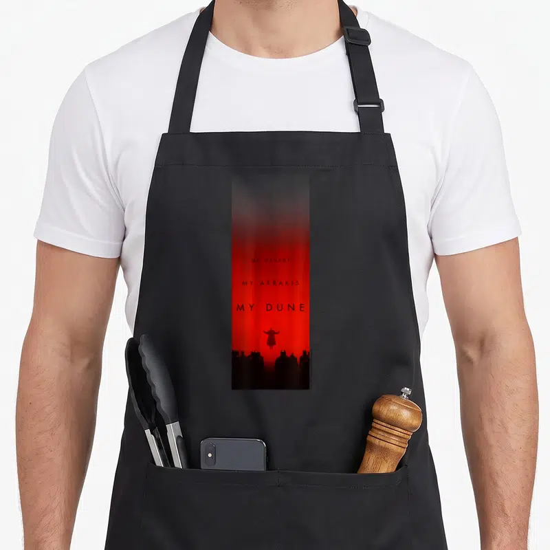Tablier de cuisine noir avec fond rouge dégradé, texte noir et silhouette centrale au-dessus d'un groupe en bas de page.