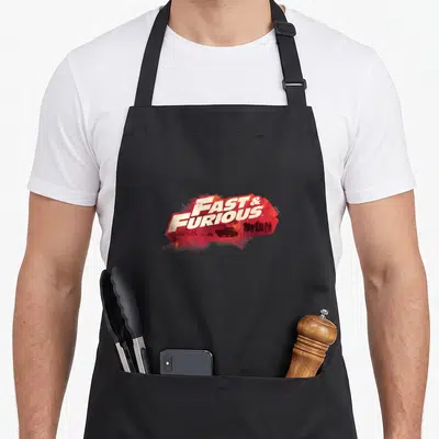 Tablier de cuisine noir avec le logo Fast & Furious en rouge vif et silhouettes sombres au centre.