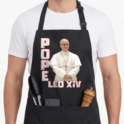 Tablier de cuisine noir avec portrait du Pape Léon XIV et texte POPE LEO XIV en blanc et rouge.