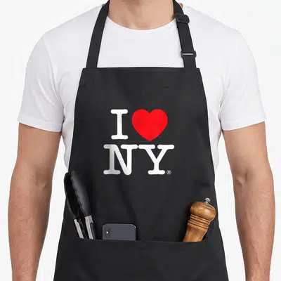 Tablier de cuisine noir avec le logo blanc I Love NY et un cœur rouge au centre du dos.