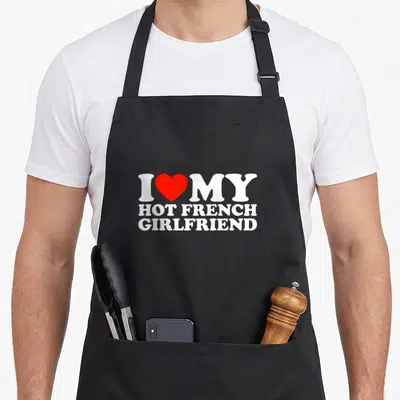 Tablier de cuisine noir avec inscription blanche I Love My Hot French Girlfriend et un cœur rouge central.