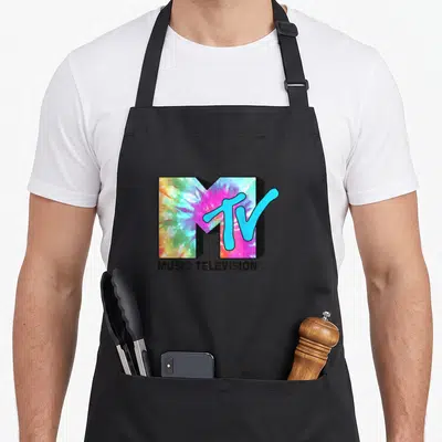 Tablier de cuisine noir avec un grand logo MTV aux couleurs tie dye et l'inscription Music Television en dessous.