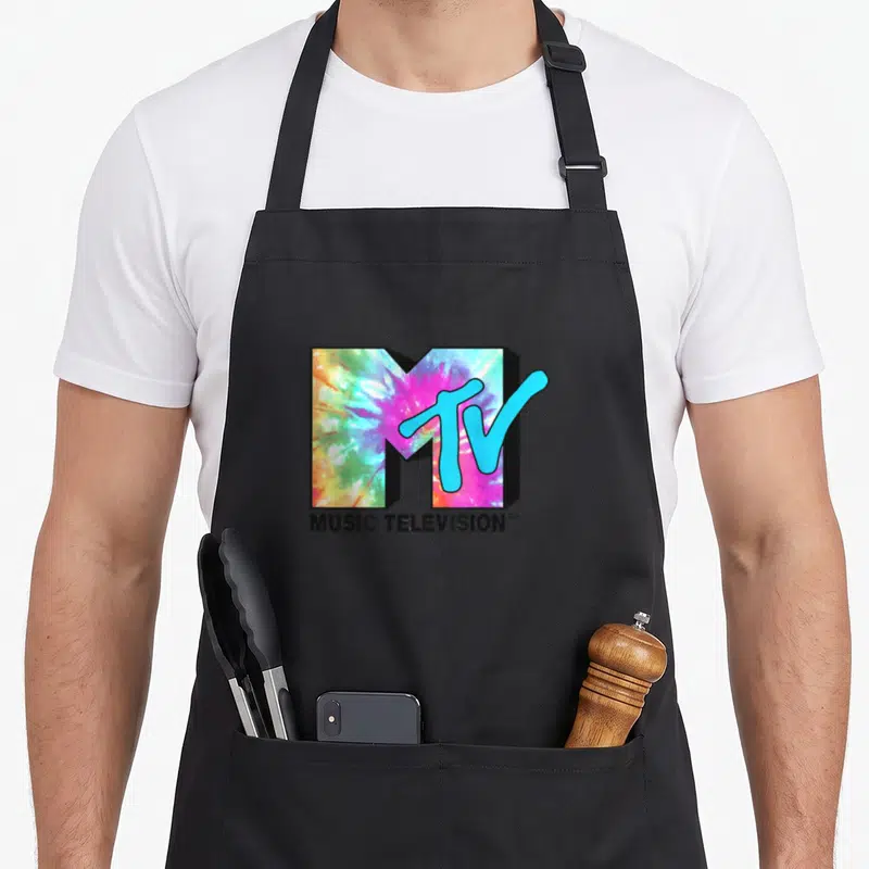 Tablier de cuisine noir avec un grand logo MTV aux couleurs tie dye et l'inscription Music Television en dessous.