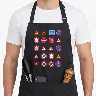 Tablier de cuisine noir avec une collection de panneaux de signalisation routière colorés imprimés sur le devant.