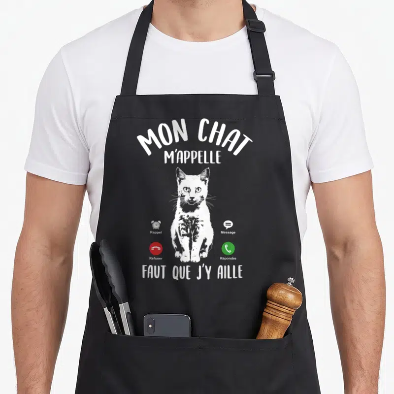 Tablier de cuisine noir avec illustration blanche d'un chat et texte humoristique imitant une interface téléphonique.