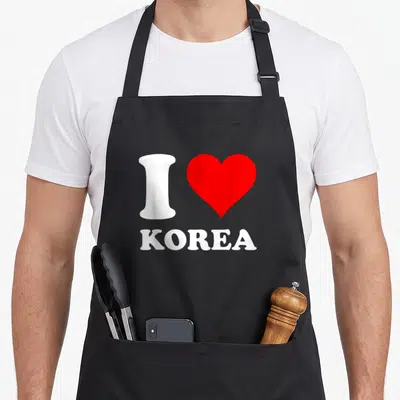 Tablier de cuisine noir avec motif blanc et rouge représentant un cœur et le mot Korea