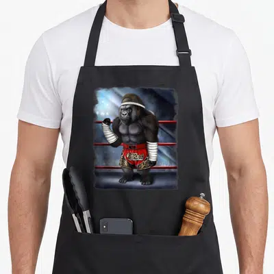 Tablier de cuisine noir avec illustration d'un gorilla combattant en Muay Thai dans un ring.