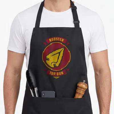 Tablier de cuisine noir avec l'insigne circulaire Rooster Top Gun en rouge et jaune.