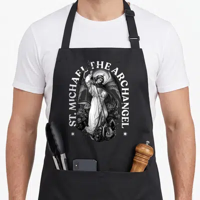 Tablier de cuisine noir avec illustration gravée de l'Archange Saint Michel tenant une lance au-dessus de démons et le texte ST. MICHAEL THE ARCHANGEL.