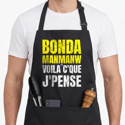Tablier de cuisine noir avec inscription Bonda Manmanw Voilà c'que j'pense en lettres jaunes et blanches texturées.