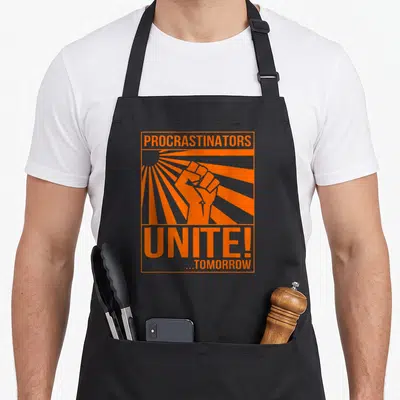 Tablier de cuisine noir avec une illustration orange d'un poing levé et le texte Procrastinators Unite Tomorrow.
