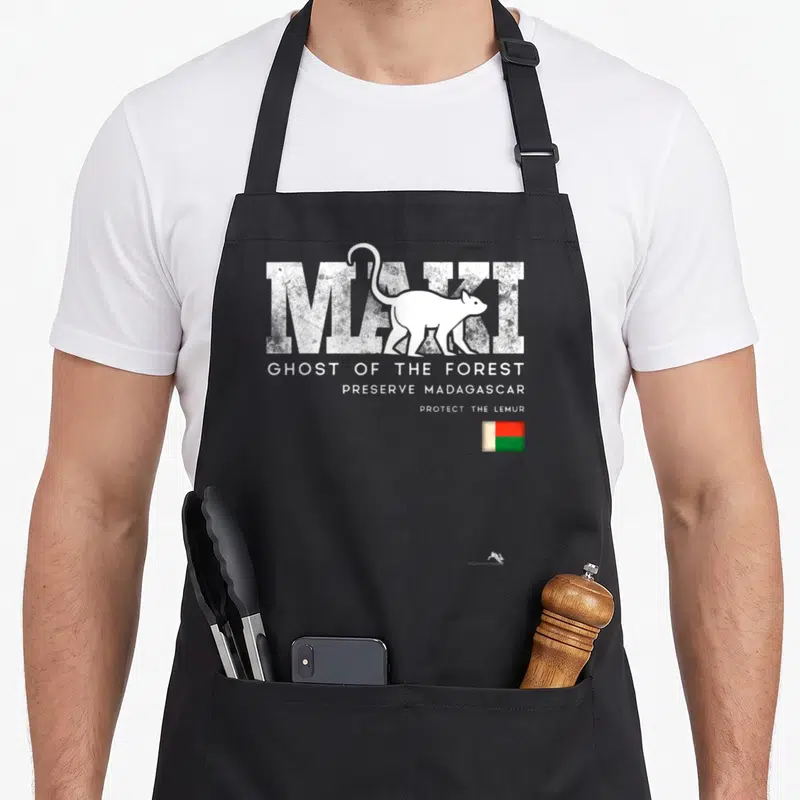 Tablier de cuisine noir avec silhouette lémurien, texte maki et petit drapeau de Madagascar en bas à droite.