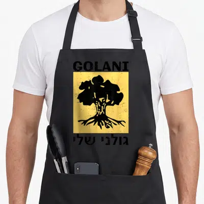 Tablier de cuisine noir avec insigne Golani, arbre stylisé noir sur fond jaune et texte en hébreu en bas.