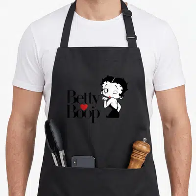 Tablier de cuisine noir avec le logo Betty Boop et une illustration de la sirène clignant de l'œil avec un cœur rouge.