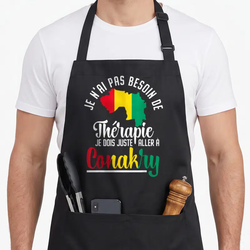 Tablier de cuisine noir avec une carte de Guinée aux couleurs du drapeau et un texte humoristique en blanc, rouge, jaune et vert.
