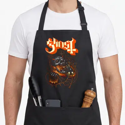 Tablier de cuisine noir avec illustration d'un démon grimaçant sur une attraction de type ghost coaster aux couleurs orangées et grisâtres.