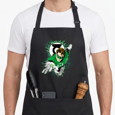 Tablier de cuisine noir avec un super-héros en tenue verte tendant la main vers l'avant devant un logo circulaire blanc et noir.