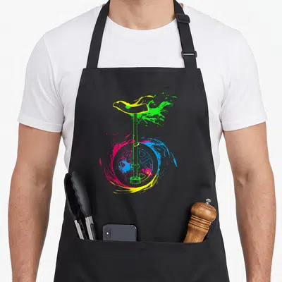 Tablier de cuisine noir avec illustration d'un monocycle vert et des éclaboussures de peinture multicolores autour de la roue.