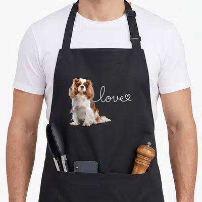Tablier de cuisine noir avec un Cavalier King Charles assis et le mot love en blanc.