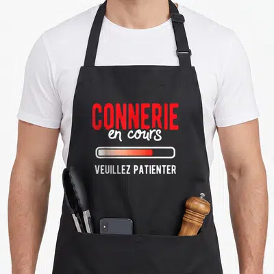 Tablier de cuisine noir avec inscription rouge Connerie en cours et barre de progression orange.
