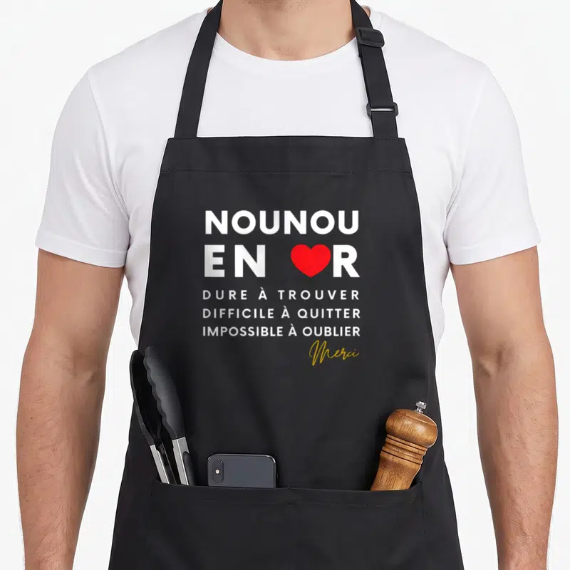Tablier de cuisine noir avec l'inscription nounou en or et un cœur rouge au centre du design.