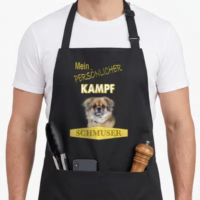 Tablier de cuisine noir avec un chiot d'épagneul tibetain et le texte jaune Mein Persönlicher Kampf Schmuser.
