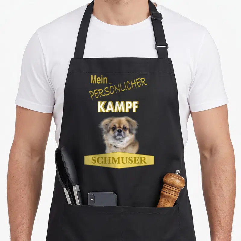 Tablier de cuisine noir avec un chiot d'épagneul tibetain et le texte jaune Mein Persönlicher Kampf Schmuser.