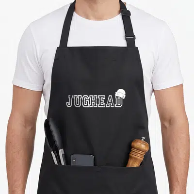 Tablier de cuisine noir avec inscription blanche JUGHEAD et petit dessin de casquette au-dessus du dernier caractère.