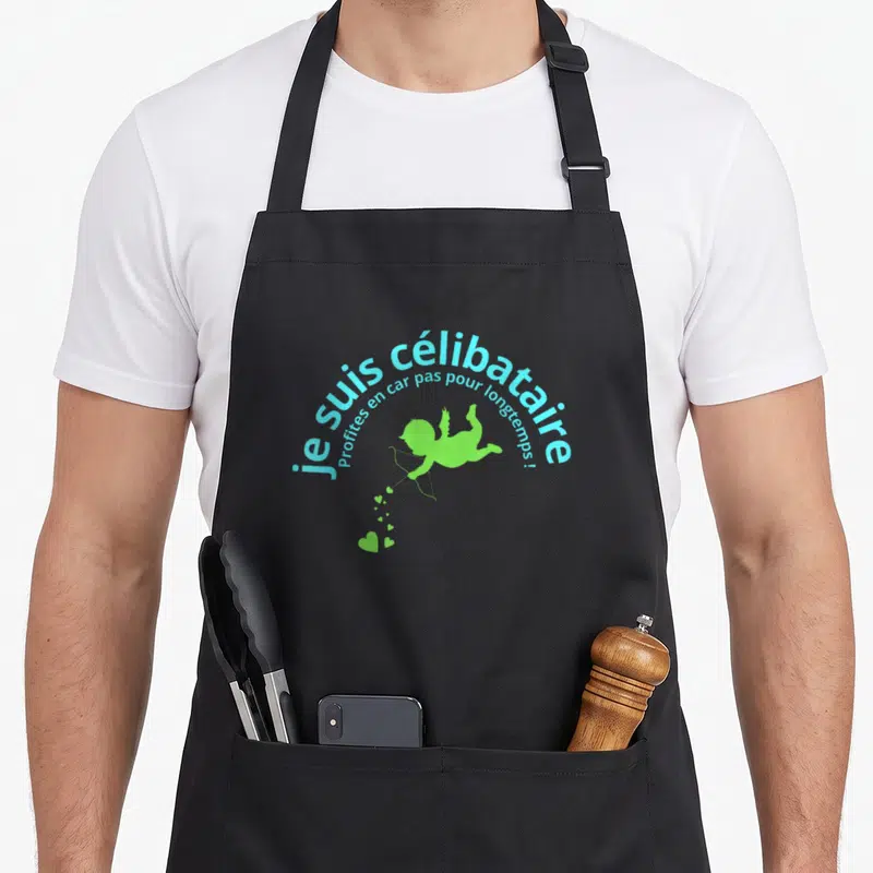 Tablier de cuisine noir avec une inscription bleue et un Cupidon vert tirant des flèches aux formes de cœurs.