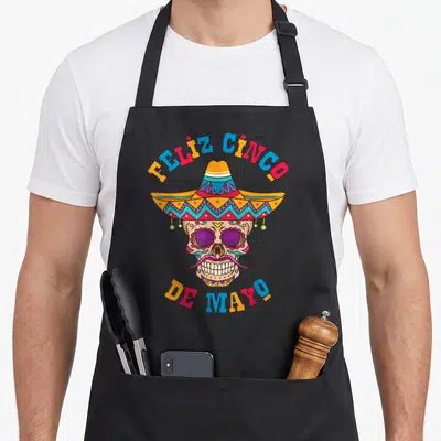 Tablier de cuisine noir avec calavera mexicaine portant un sombrero coloré et une moustache violette sous les textes Feliz Cinco de Mayo.
