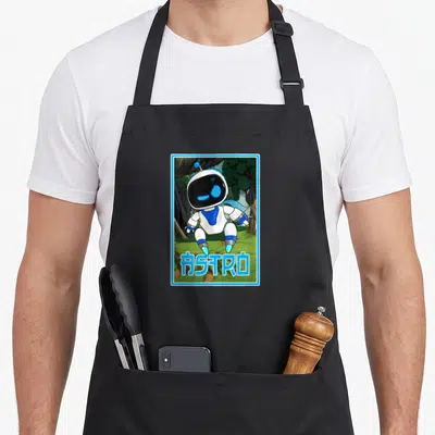 Tablier de cuisine noir avec illustration d'un robot Astro blanc et bleu debout sur un pré vert entouré d'arbres.
