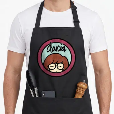 Tablier de cuisine noir avec logo circulaire Daria, bordure bordeaux et portrait de la protagoniste aux lunettes.