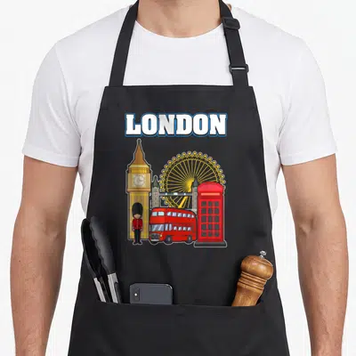 Tablier de cuisine noir avec illustration colorée de Big Ben, d'un bus rouge et d'une cabine téléphonique londonienne.