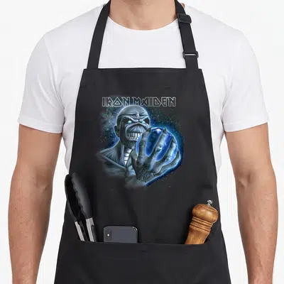 Tablier de cuisine noir avec illustration d'Eddie tenant une sphère bleue sous le logo Iron Maiden en style sketch.