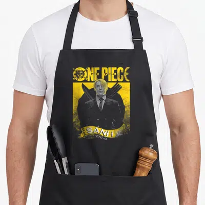 Tablier de cuisine noir avec portrait stylisé de Sanji en costume et ustensiles de cuisine croisés sur fond jaune texturé.