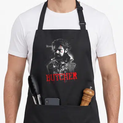 Tablier de cuisine noir avec portrait blanc et texte rouge BUTCHER en style graffiti.