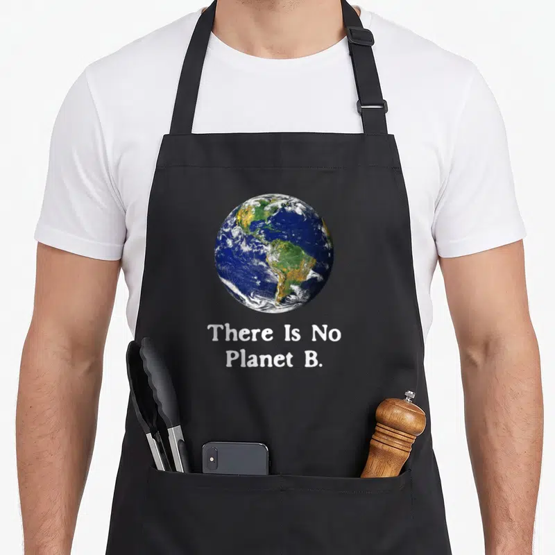 Tablier de cuisine noir avec une illustration réaliste de la Terre et le texte blanc There Is No Planet B.