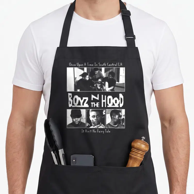 Tablier de cuisine noir avec une illustration en noir et blanc représentant quatre personnages et le titre Boyz n The Hood au centre.