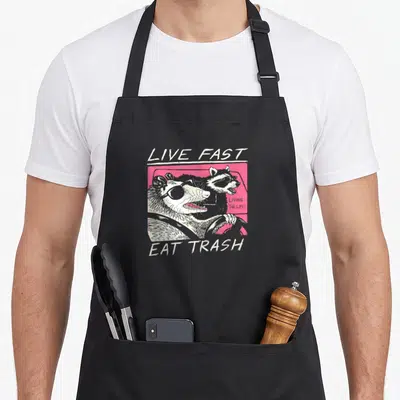 Tablier de cuisine noir avec illustration de deux rats laveurs portant des lunettes de soleil au volant d'une voiture rose vif.