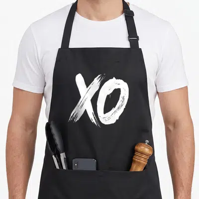 Tablier de cuisine noir avec l'inscription XO blanche au style calligraphie brush sur le devant