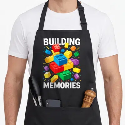 Tablier de cuisine noir avec des briques de construction colorées et les mots Building Memories en blanc.