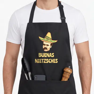 Tablier de cuisine noir avec tête de Nietzsche coiffé d'un sombrero et l'inscription Buenas Nietzsches en lettres jaunes.