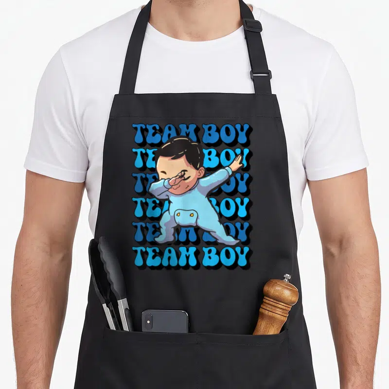 Tablier de cuisine noir avec illustration d'un bébé effectuant le dab et le texte Team Boy en arrière-plan.