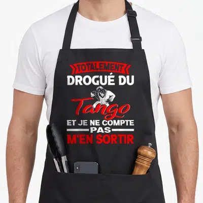 Tablier de cuisine noir avec une illustration de couple dansant le tango et un slogan humoristique en rouge et blanc.