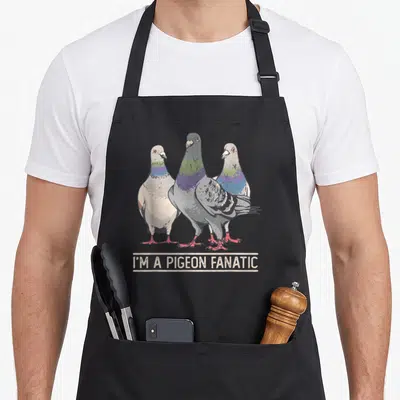 Tablier de cuisine noir avec trois pigeons stylisés et l'inscription I'M A PIGEON FANATIC en bas.