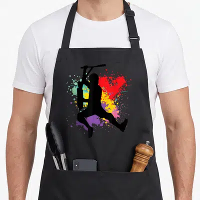 Tablier de cuisine noir avec silhouette trottinette freestyle et éclats de peinture colorés.
