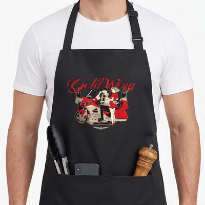 Tablier de cuisine noir avec une illustration Gold Wing rouge et crème accompagnée d'un couple en tenue rétro.